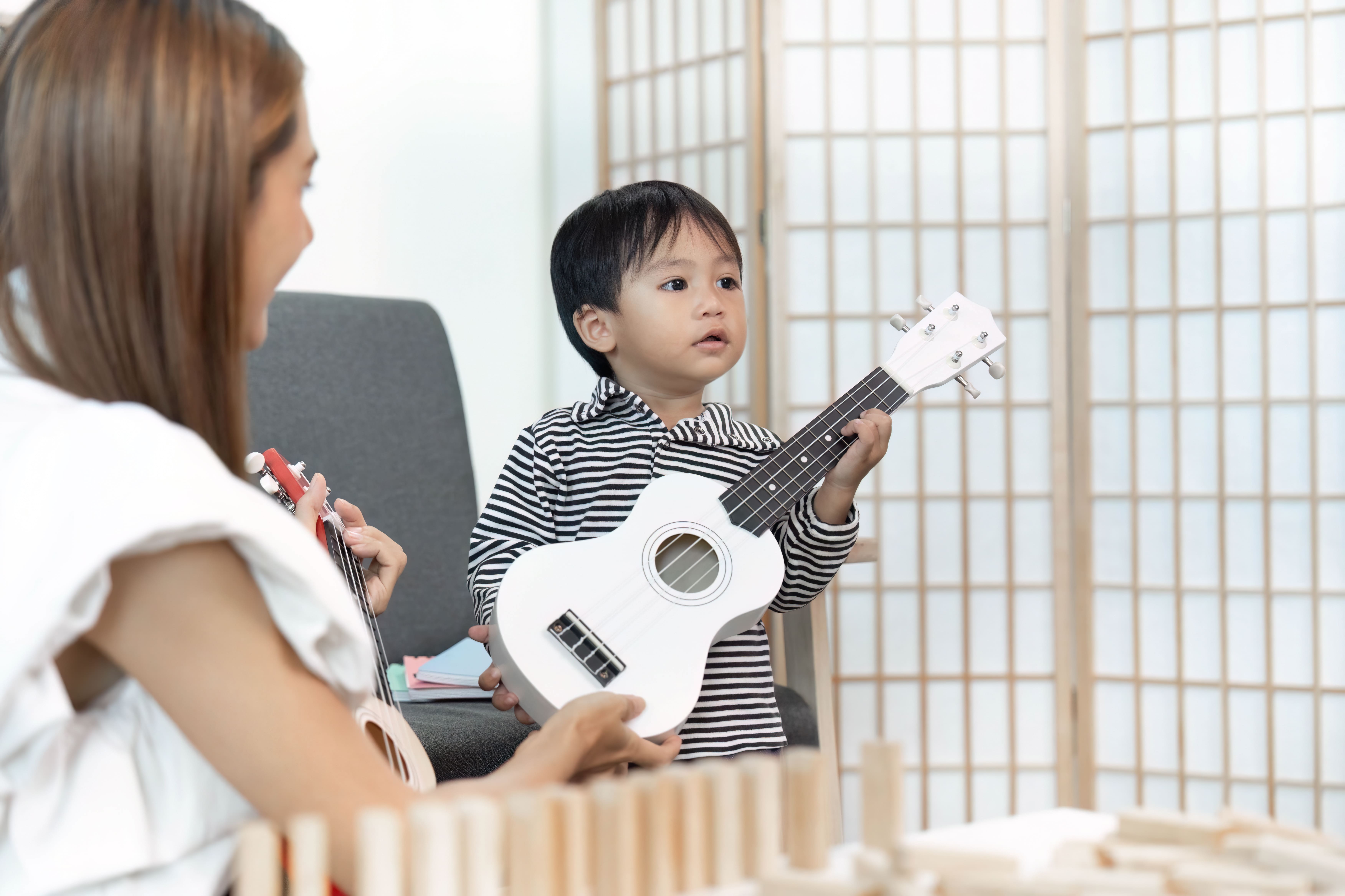 Grupo de mayores en Granada participando en musicoterapia, tocando instrumentos y sonriendo, mejora de la calidad de vida con música